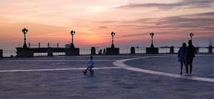 tramonto, lampioni, mare, bambino, nuvole, cielo, persone, coppia, bicicletta, lungomare, piazza, triciclo, piazzale, terrazza, nave, parapetto, grigio, controluce, arancione, strisce, sera